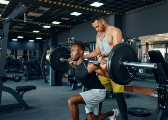 Person performing a split squat in a bright, modern gym, emphasizing core stability and hip function.